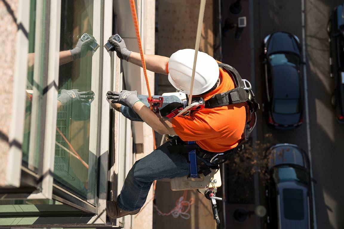 commercial leak repair high rise building worker on rope descent